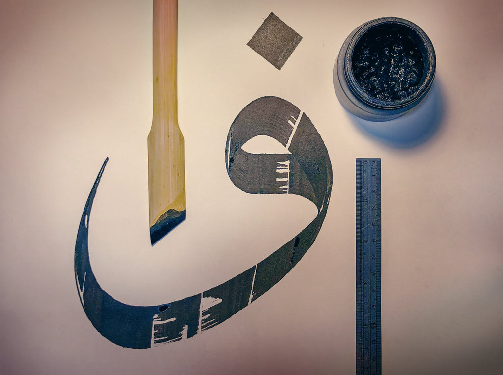 Arabic calligraphy instruments displaying bamboo pen, ink well, ruler and written letter Wau or Va in Jawi.