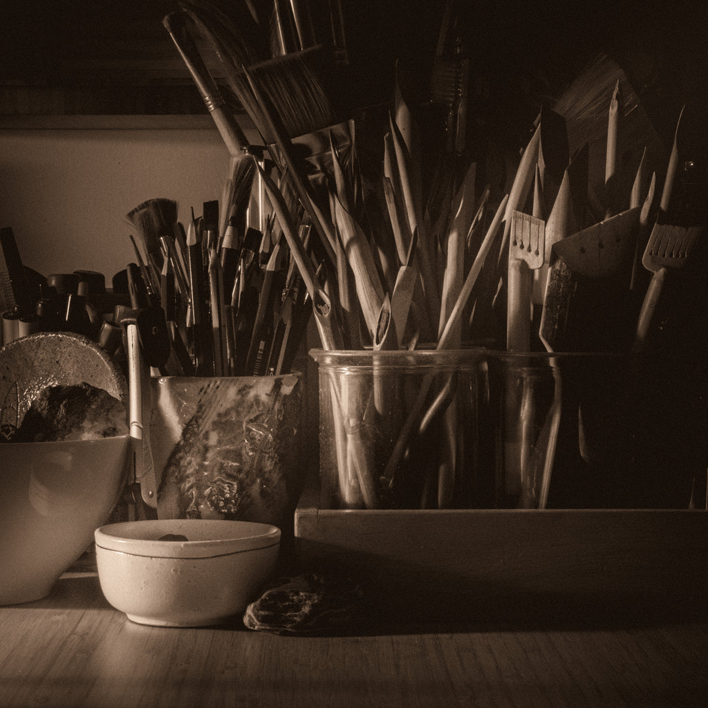 Calligraphy and drawing tools on table in a studio.