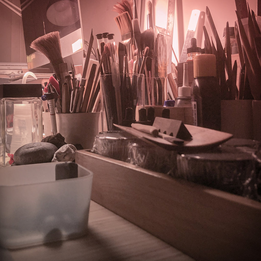 Artist studio work table with calligraphy pens, drawing tools and illustration painting brushes.