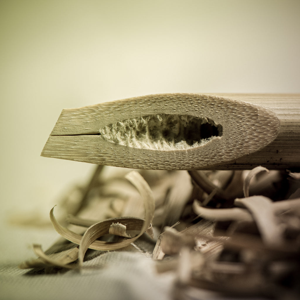 Close up of Arabic calligraphy wooden bamboo pen nib on a pile of wood shavings.